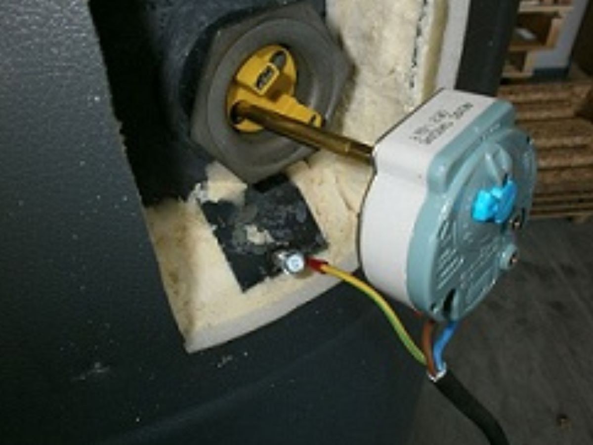 Sonde bleue de thermostat enfoncée dans le logement de résistance d'un ballon, fils marron, bleu et terre.