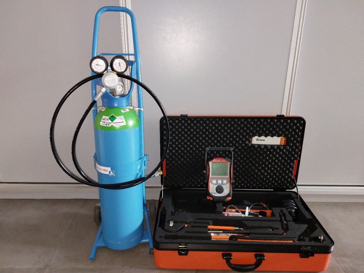Bouteille bleue Air Liquide d'azote et hydrogène sur un diable, mallette orange ouverte avec détecteur.